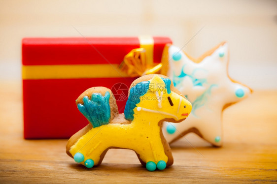 土制姜饼小马和明星有冰淇淋和彩色装饰有金丝带的红礼品盒克里斯马和节日手工制作的概念图片