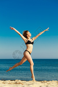 暑假穿比基尼的姑娘在海滩上跑步年轻女人在海边放松愉快夏天图片
