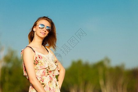 渡假穿暑期礼服的女孩和太阳镜站在空旷的海滩上年轻女人在海边放松夏天图片