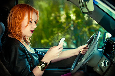 年轻女司机在开车时手上发短信图片