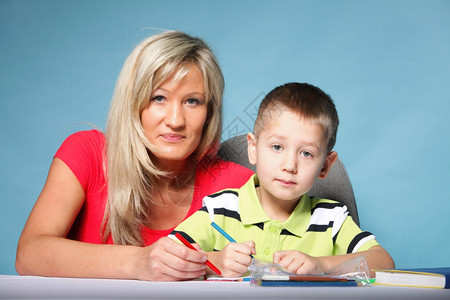 母亲帮助儿子一起做家庭作业图片