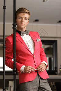 年轻英俊的时装模特穿着明亮的红色夹克身着室内领带图片