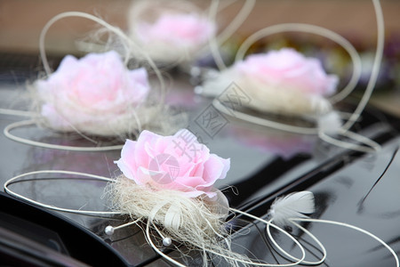 带有粉红色花和丝带装饰的婚礼轿车图片