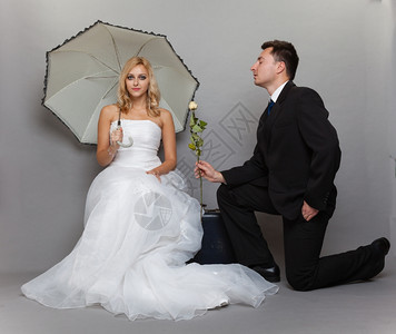 今天是结婚日浪漫已夫妇金发新娘的肖像配着雨伞的金发新娘和深色郎给女孩送玫瑰图片