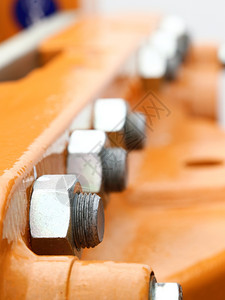 工业机械橙色件细节上的螺丝和栓图片