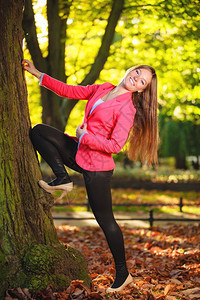 秋天季节公园森林里粉红色的年轻快乐少女户外图片