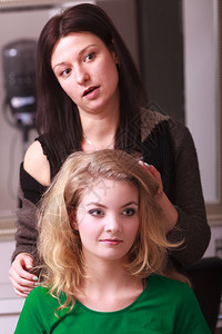 美丽的笑脸女孩金发卷美师的女郎在容院快乐的年轻女子发型图片