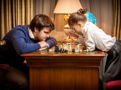 男人跟聪明的小女孩输了象棋游戏图片