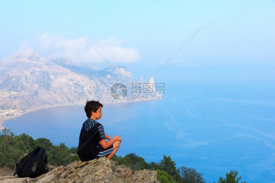 年轻旅行者坐在山顶看风景图片