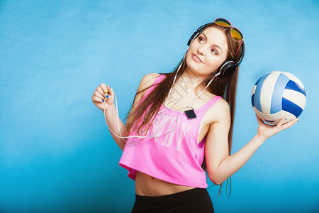 时装少女耳机听音乐mp3播放器新鲜的精力充沛年轻女青放松快乐跳着蓝球背景的舞图片