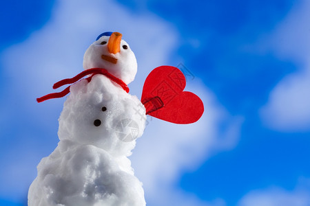 圣诞小雪人穿着蓝螺丝顶的色戴着帽子红围巾外出贴色心爱的短片符号冬季节情人39白昼蓝天空背景图片
