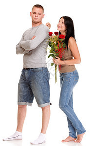 美丽的年轻快乐笑一对被孤立情侣爱肖像男人跪在膝下给他的女朋友一朵玫瑰而那个女孩则被孤立在白色上图片