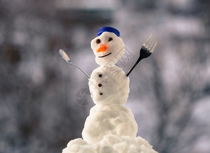 小快乐的圣诞节雪人蓝螺帽顶部的色丝帽子红围巾外出有叉茶匙冬季节模糊的背景图片