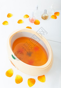 碗和花瓣中的橘子蜡美容和院的皮肤护理图片