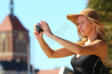 时髦的秋天旅行女游客戴着照相机在欧洲城外拍摄故乡格丹斯克波兰欧洲背景图片