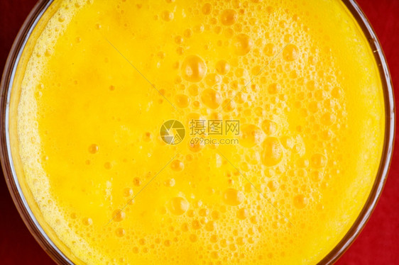 关闭红底的新鲜夏季饮料黄果汁图片