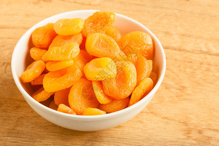健康的营养饮食一碗木桌底的干杏子图片