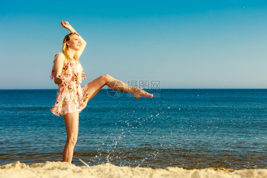 暑假穿期服的姑娘在海岸上泼水年轻女人在海上放松愉快夏天图片