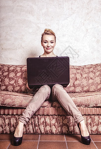 技术互联网现代生活方式概念使用笔记本电脑在回放沙发上工作的全时年轻商业妇女或学生室内旧照片图片