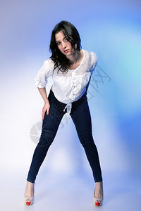 穿着时装牛仔裤穿着蓝底高跟鞋的时尚年轻又大的女人肖像图片