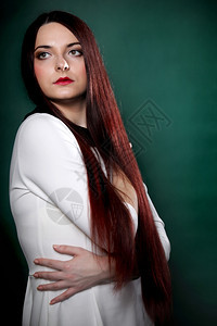 女孩直长的黑头发装扮成演唱室时拍摄绿色背景照片图片