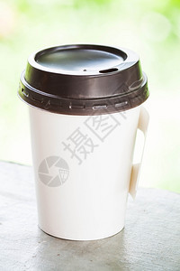 热咖啡纸杯加绿色bokeh图片