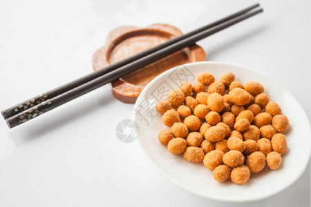 白桌上的辣花生小吃和筷子图片