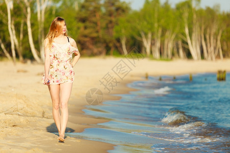 暑假穿期服装的女孩独自在空旷的海滩上行走年轻女人在海上放松夏天图片