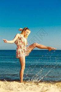 女性洗脸泼水暑假穿期服的姑娘在海岸上泼水年轻女人在海上放松愉快夏天背景