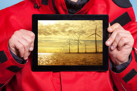 男手紧握着风力涡轮机农场照片的皮帕显示屏幕平板电脑触摸推荐可再生能源和的人技术和环境图片