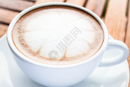 咖啡拉花木椅上的热咖啡有美丽的拉花图案背景