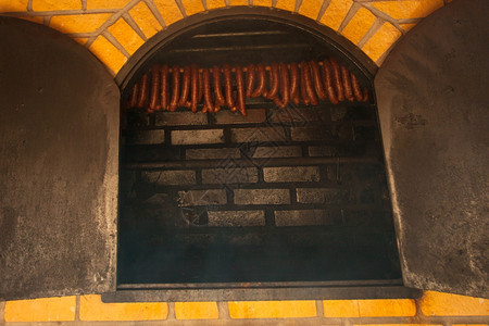 传统食物家用烟熏香肠肉挂在家用烟屋里图片