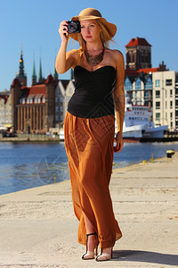 时髦的秋天旅行女游客戴着照相机在欧洲城外拍摄故乡格丹斯克波兰欧洲图片