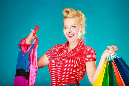 粉色衣服客户拿着鲜艳的纸袋蓝色零售和销工作室拍摄图片