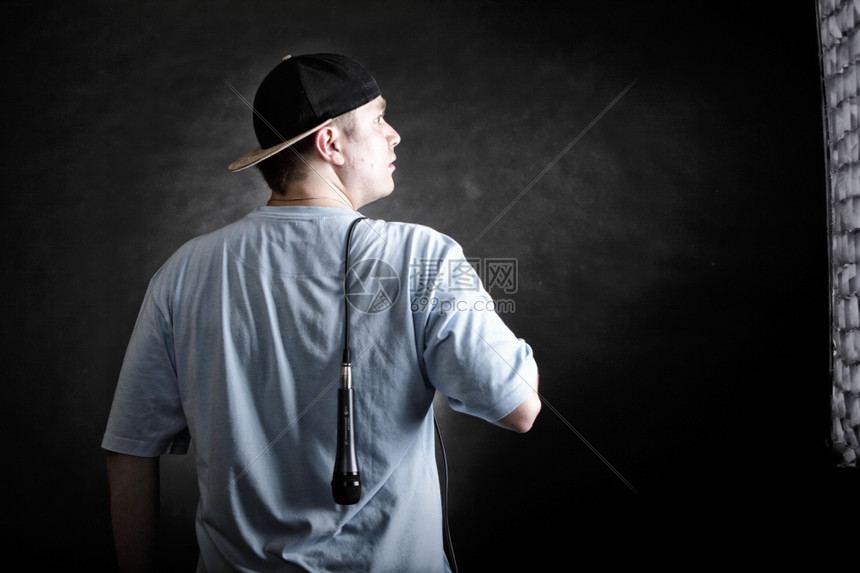 rapper态度说唱歌手跳舞表演年轻人带帽子麦克风背面观看黑色的粗野