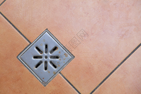 下水道沟浴室瓷砖地板上的排水图片
