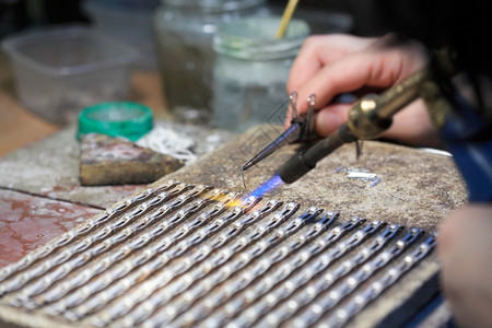 珠宝商在工作时的手银焊黄金匠在打工和焊接高清图片