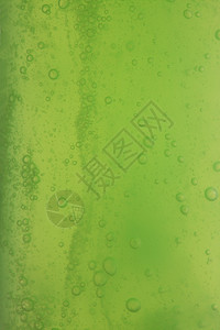 含有肥皂泡沫的绿色抽象模糊液体背景图片