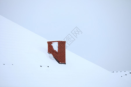 雪上盖着屋顶的红烟囱图片