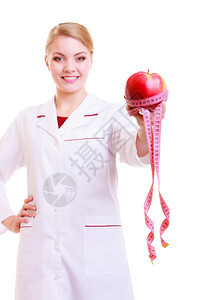 白大衣上的女人建议吃健康食品医生带水果苹和豆类胶带的饮食部位被隔离图片