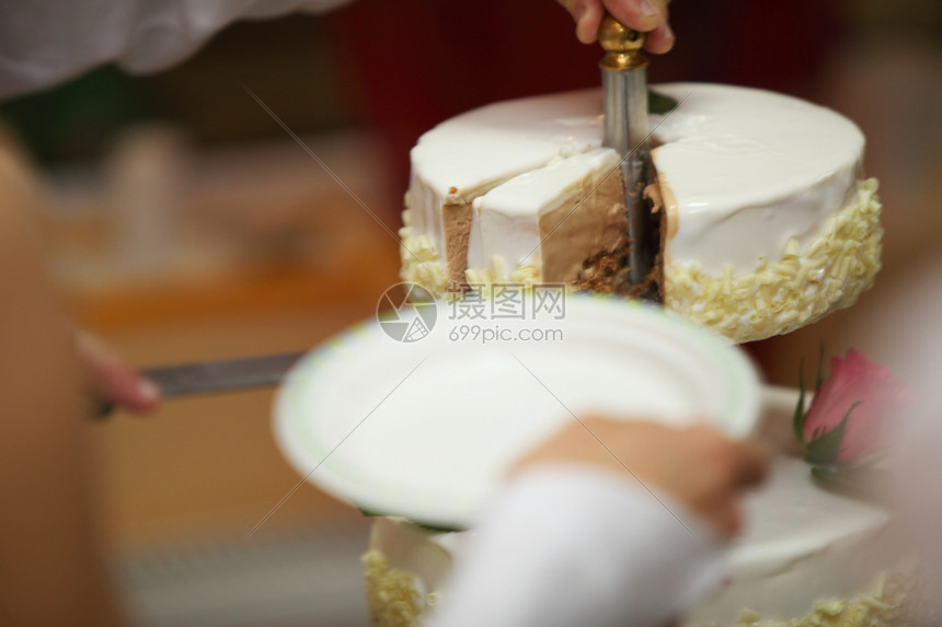 一只手用刀切美丽的巧克力结婚蛋糕图片