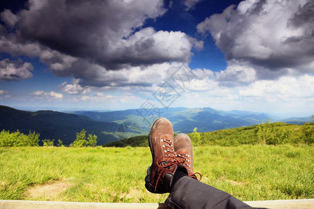 漫步鞋靴男徒旅行者享受观光放松地看山脉的自然图片