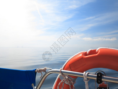 救红色生艇员在帆船和蓝天黄海上保护环图片