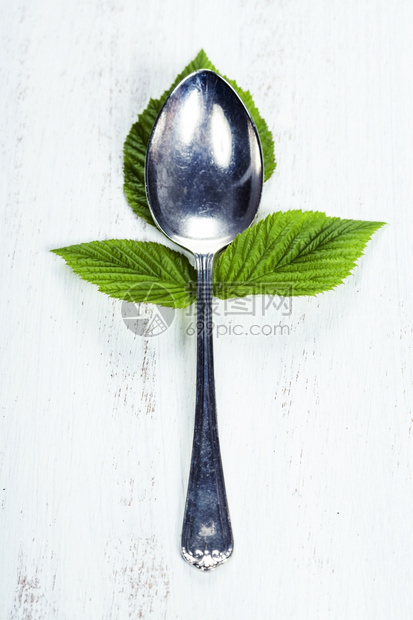 带新鲜草莓叶的勺子健康饮食素品概念图片
