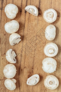蔬菜食品新鲜白色蘑菇框架木制厨房餐桌背景的冠军图片