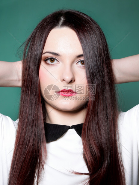 女孩直长的黑头发装扮成演唱室时拍摄绿色背景照片图片