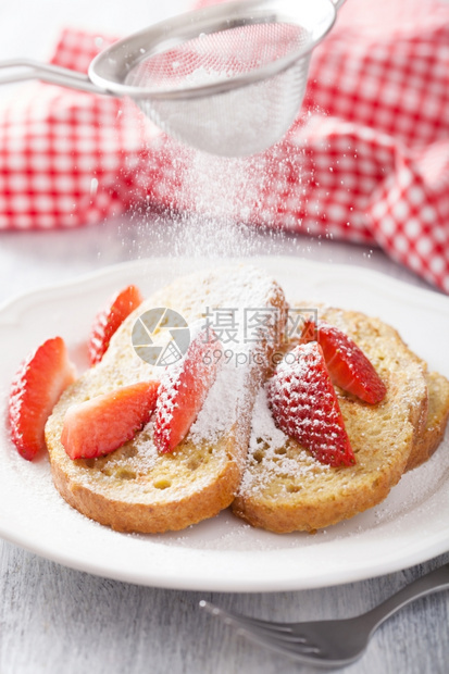 在法国吐司上加草莓的粉末糖图片