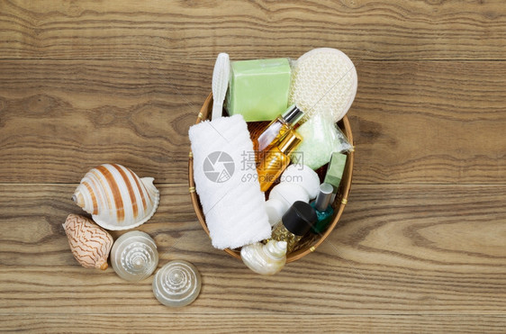 放在生锈木板篮子上的浴缸和淋配件的俯视包括毛巾洗刷润滑剂肥皂浸泡盐香水和海壳图片