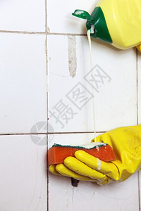 用手套清洗间用海绵的脏旧瓷砖图片