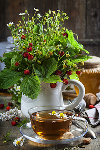 配有草药茶和蜂蜜的野草莓花束生物食或健康概念图片